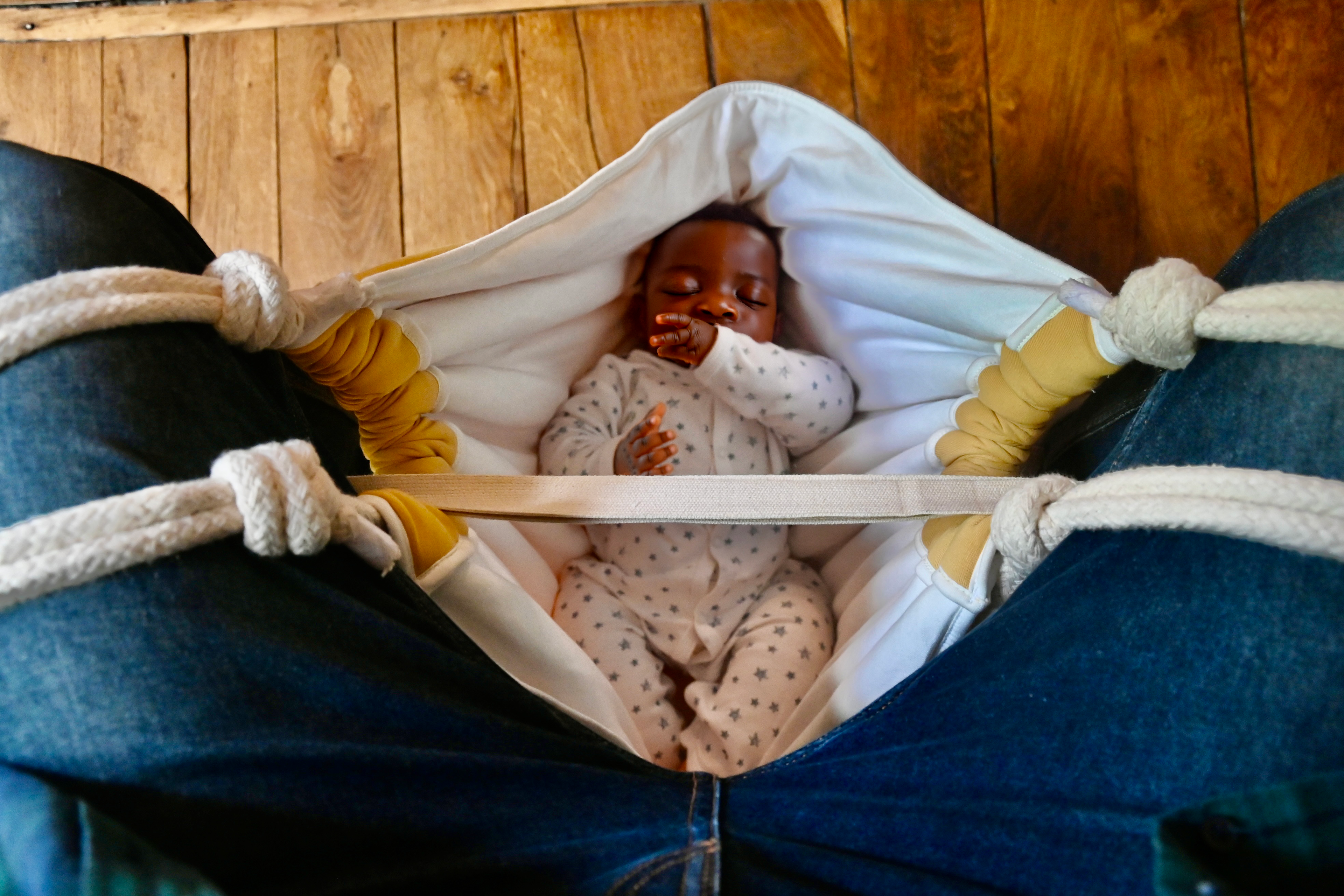 Baby in a hammock with wooden background